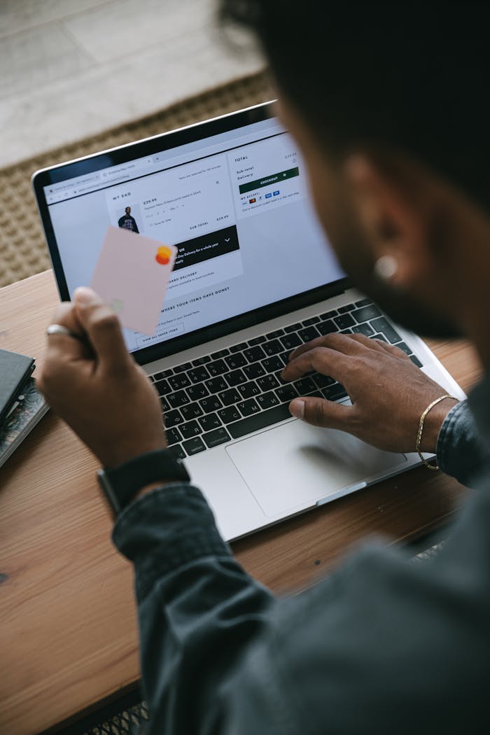 Person shopping online using a laptop and credit card.